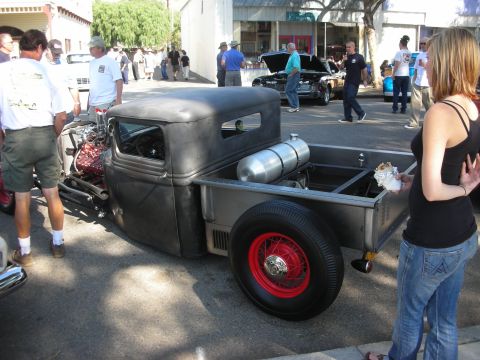 1998 Ford Crown Victoria - Rat rod pickup truck at a car show, with other vehicles and spectators in the background.