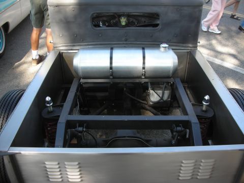 1998 Ford Crown Victoria - The bed of a custom truck shows a large fuel tank, suspension, and part of the drivetrain.