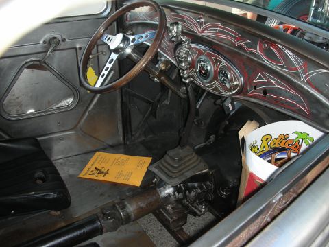 1998 Ford Crown Victoria - The interior of a custom hot rod features a wooden steering wheel, unique pinstriping on the dashboard, and a floor-mounted shifter.
