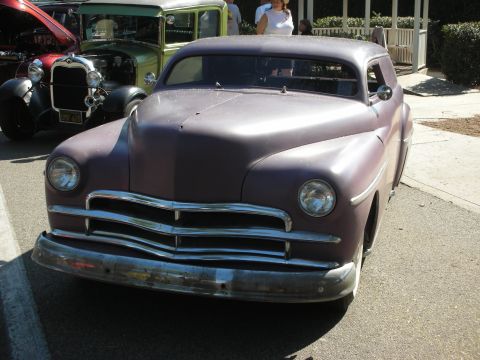 1998 Ford Crown Victoria - A vintage purple coupe is parked at an outdoor event with other vehicles.