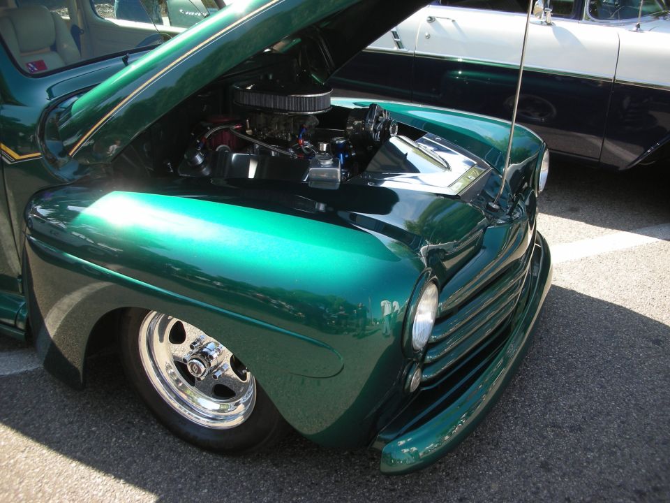 Green 1948 Ford pickup hot rod with open hood and chrome engine