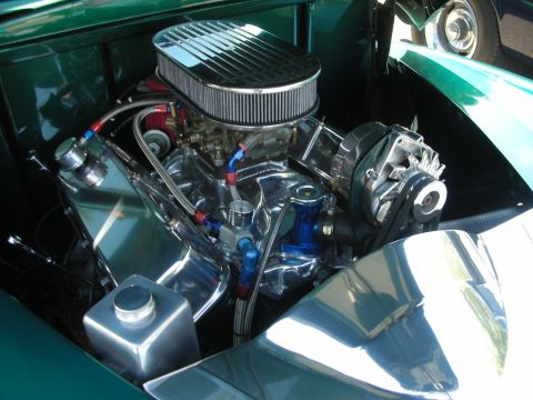 1998 Ford Crown Victoria - The engine bay of a custom car features a polished V8 engine with performance parts.