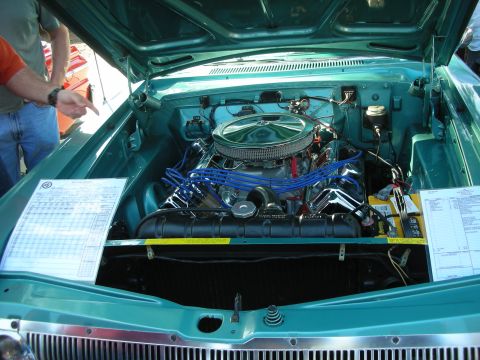1998 Ford Crown Victoria - The engine bay of a classic car is shown with a prominent V8 engine and various components. A document is placed on the fender for display.