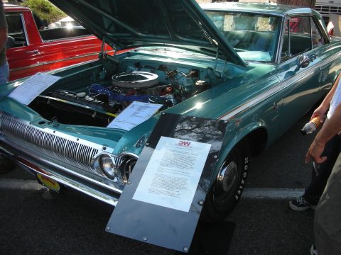 1998 Ford Crown Victoria - A teal coupe from 1964 is displayed with its hood open, revealing the engine and information placards.