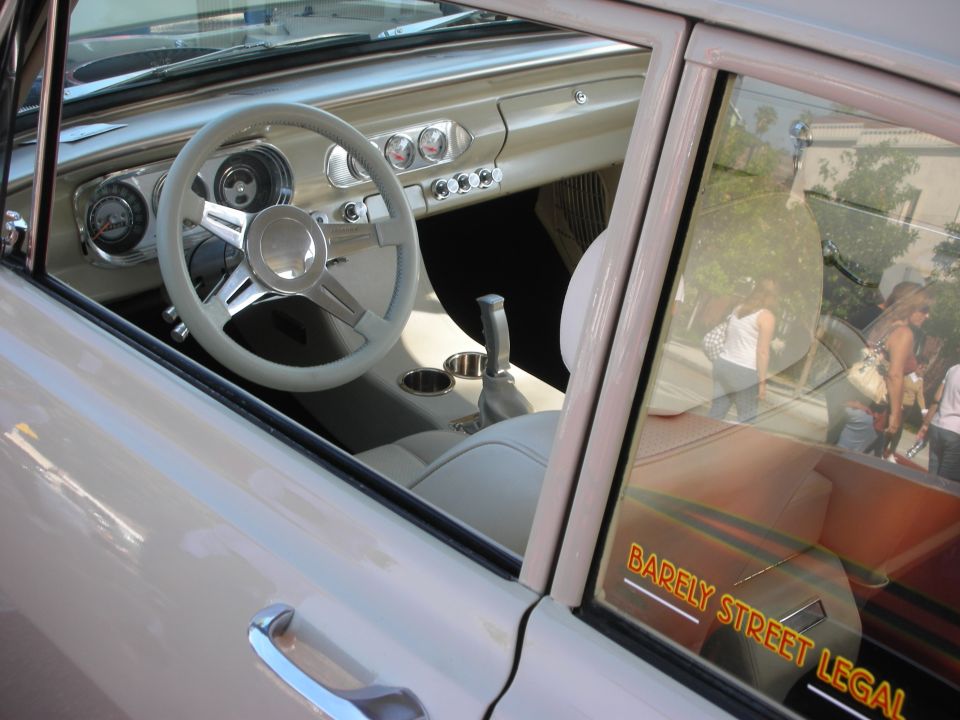 Classic car interior through window with billet steering wheel and 'BARELY STREET LEGAL' decal
