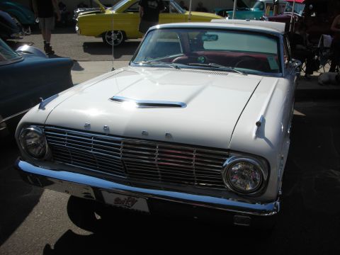1998 Ford Crown Victoria - A white 1960 Ford Falcon is parked at a car show with other vehicles visible.