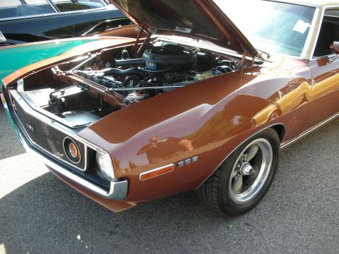 1998 Ford Crown Victoria - Front view of a brown 1970 AMC Javelin AMX with its hood open, parked next to other vehicles.
