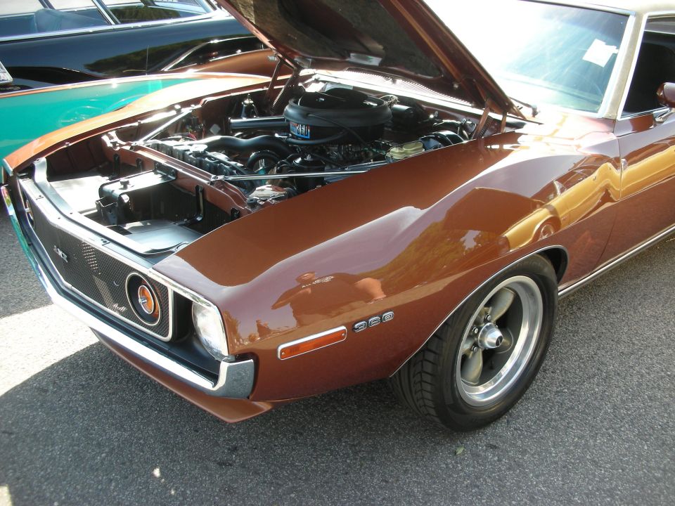 Brown AMC Javelin style fastback coupe with open hood, front three-quarter at car show
