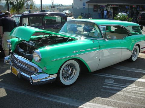 1998 Ford Crown Victoria - A two-tone green and white 1955 Buick Century Caballero station wagon is displayed with its hood open, wire wheels and a classic body style.