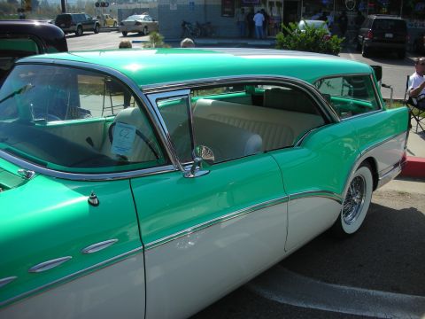 1998 Ford Crown Victoria - Two-tone green and white station wagon with whitewall tires, side profile.