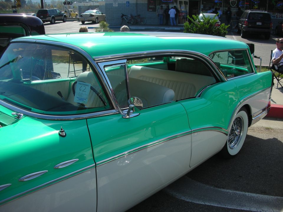 Side profile of green and white 1950s Buick wagon with white interior