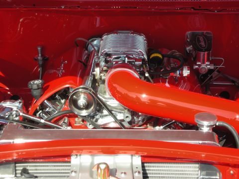 1998 Ford Crown Victoria - Close-up view of a polished engine bay, chrome components and a prominent red intake tube.
