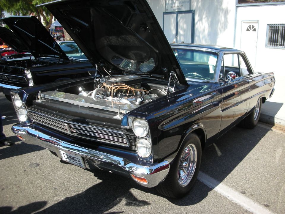 Dark blue 1965 Mercury Comet hardtop with hood open at car show