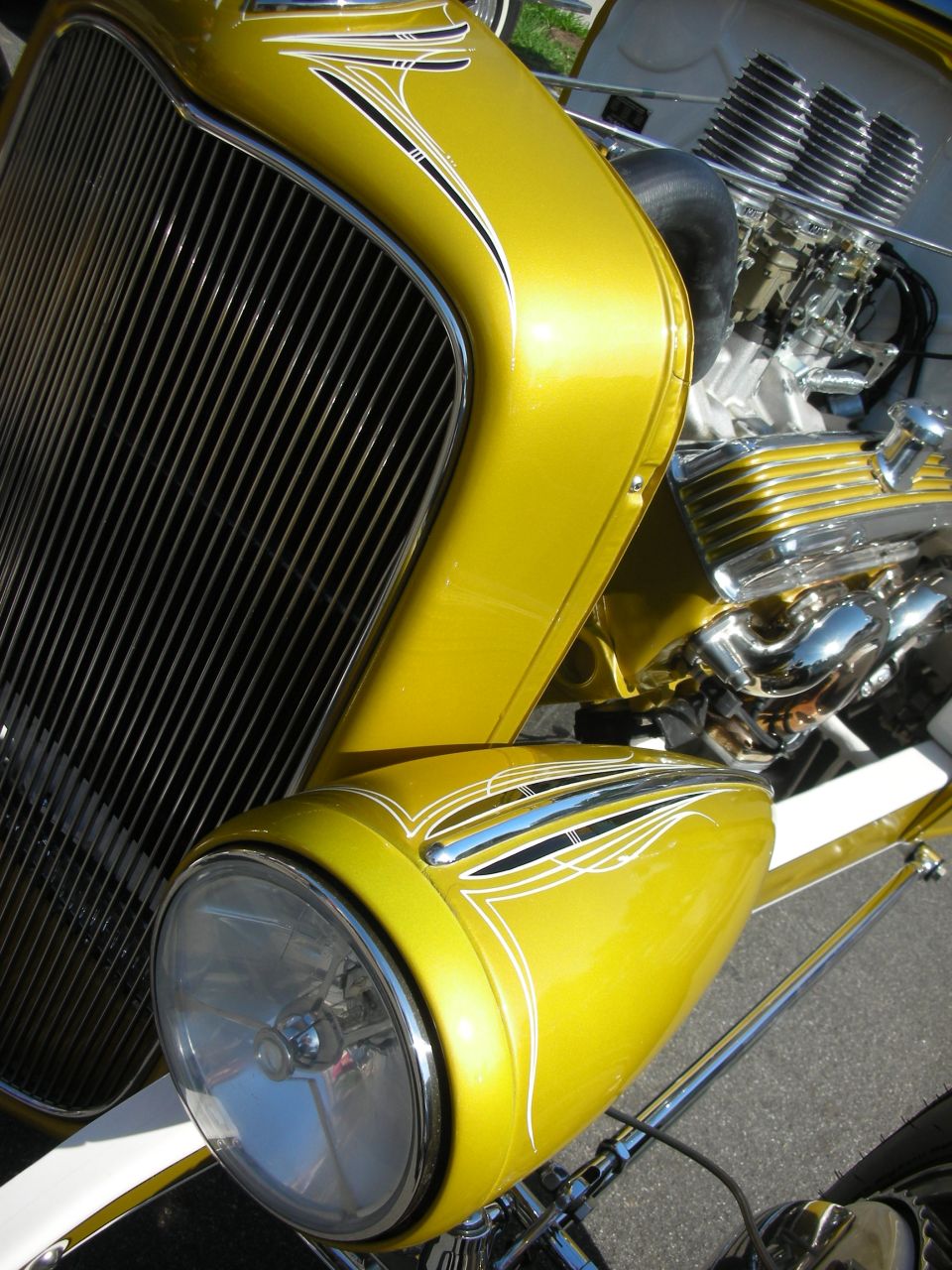 Close-up of gold pinstriped hot rod grille shell and headlight