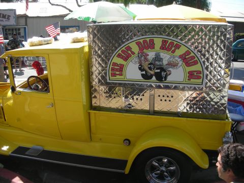 1998 Ford Crown Victoria - A vintage yellow truck converted into a hot dog stand with a distinctive chrome enclosure and signage.