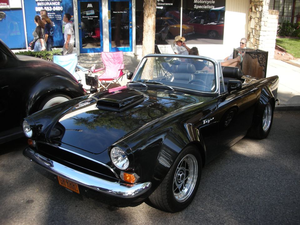 Black Sunbeam Tiger roadster with hood scoop at a street car show