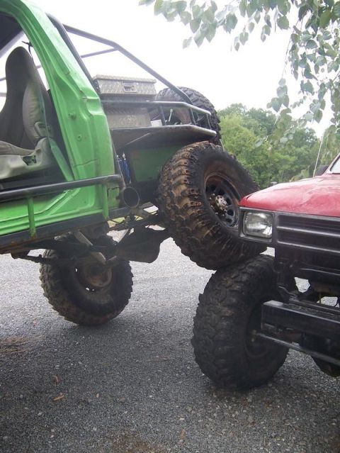 1978 Ford Bronco - Two modified off-road vehicles are shown in close proximity, one green and one red.