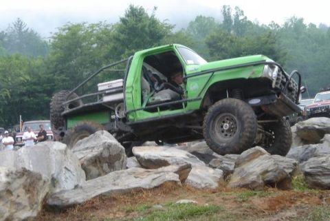 1978 Ford Bronco - A modified green off-road vehicle tackles a rocky obstacle course.