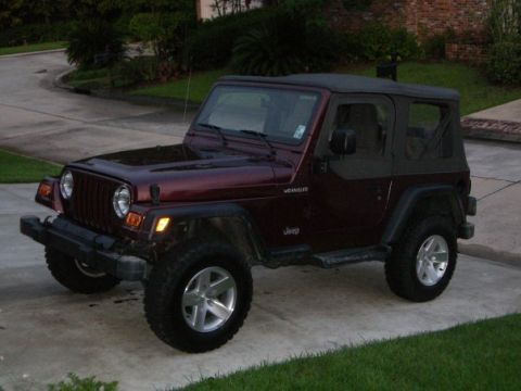 1995 Ford Bronco - This maroon Jeep Wrangler is shown from a 3/4 front angle, a soft top and aftermarket wheels.