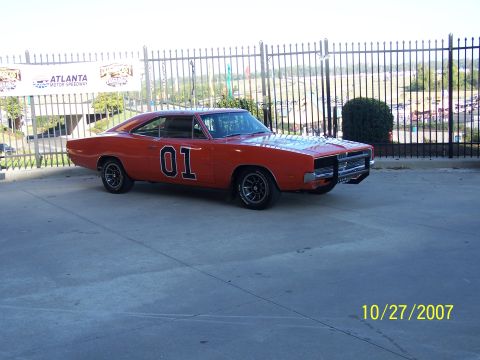 1979 Ford F-150 - Orange 1969 Dodge Charger with "01" on the door, parked outside Atlanta Motor Speedway.