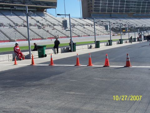 1979 Ford F-150 - A race track scene with traffic cones and spectator seating visible under a clear sky.