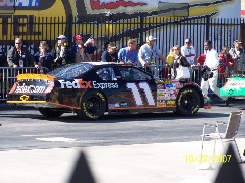 1979 Ford F-150 - A race car with FedEx Express livery and the number 11 is seen with spectators in the background.