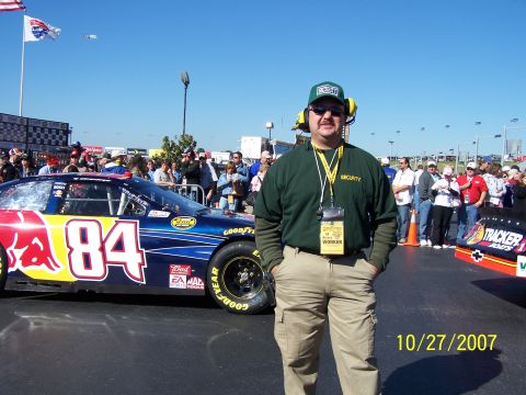 1979 Ford F-150 - A worker stands next to a NASCAR race car at a track event. The date 10/27/2007 is visible.