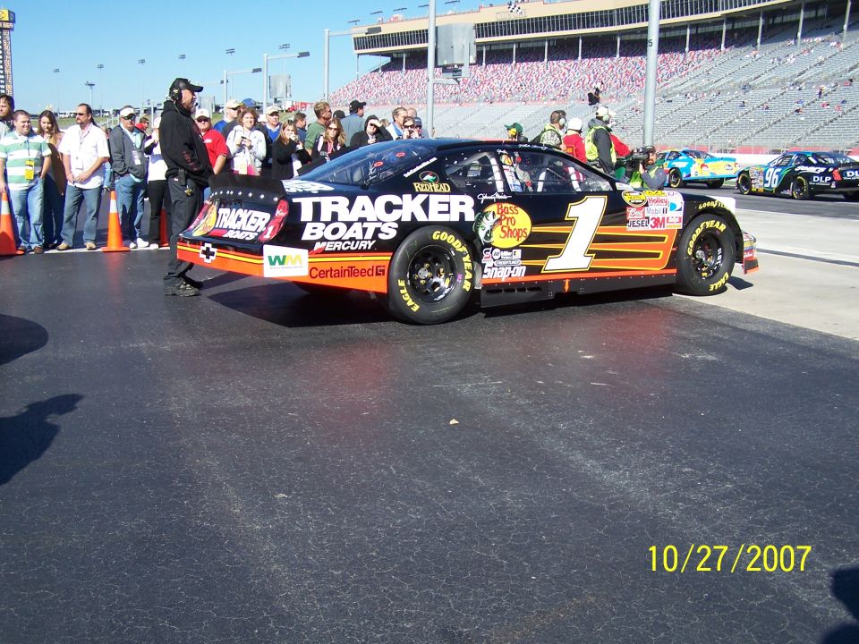 NASCAR race car with 'Tracker Boats' livery, number 1, on pit road with spectators and other cars in background. Date stamp 10/27/2007