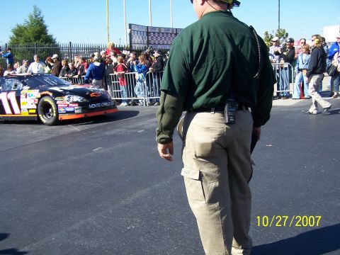 1979 Ford F-150 - A NASCAR race car with the number 11 is visible on a track, with spectators in the background.