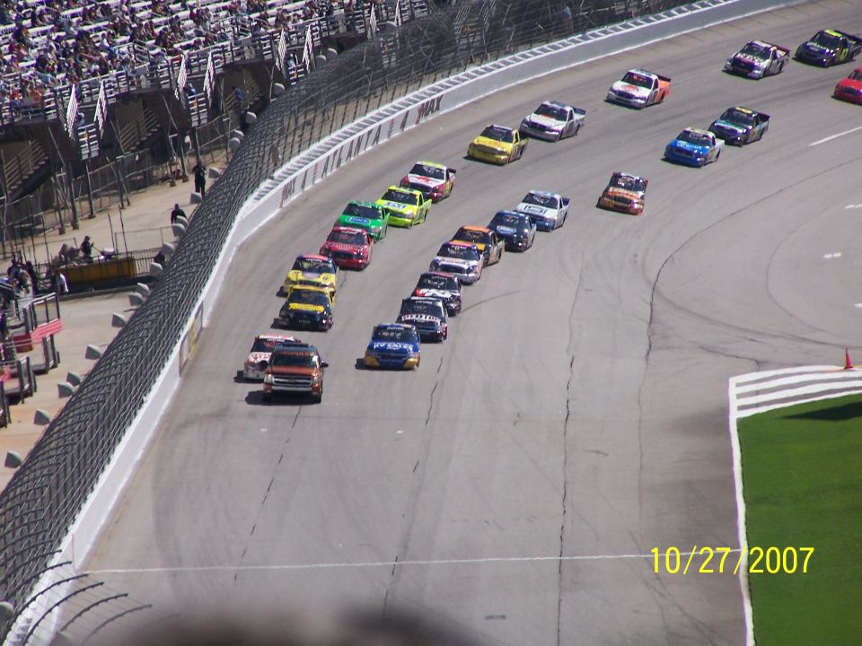 Stock cars racing on a track, date 10/27/2007 visible