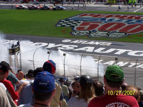 1979 Ford F-150 - Race cars speed around Atlanta Motor Speedway, creating smoke near the finish line.