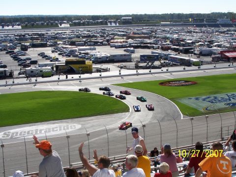 1979 Ford F-150 - A race is underway with multiple cars on the track, and spectators watching from the stands.