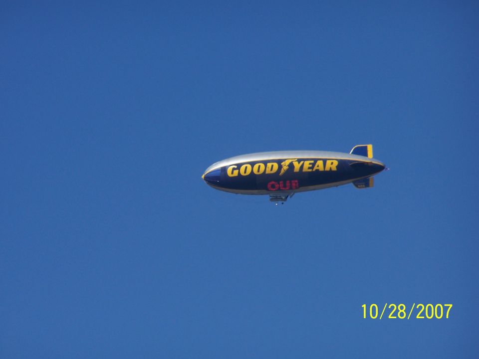 Goodyear blimp flying in a clear blue sky. Date stamp reads 10/28/2007
