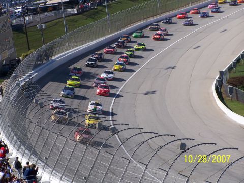1979 Ford F-150 - Stock cars compete on a race track during a sunny day.