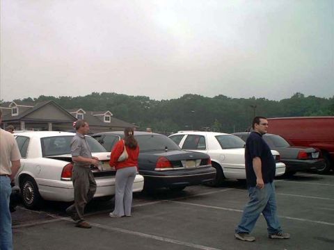2000 Ford Crown Victoria - A white 2000 Ford Crown Victoria is seen parked in a lot with other vehicles.