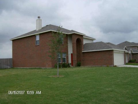 1992 Ford Bronco - A brick house with a white garage door and a well-kept lawn under a cloudy sky.