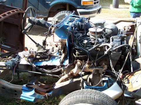 1995 Ford Bronco - Disassembled 1995 Ford Bronco chassis showing engine, steering, and frame components.