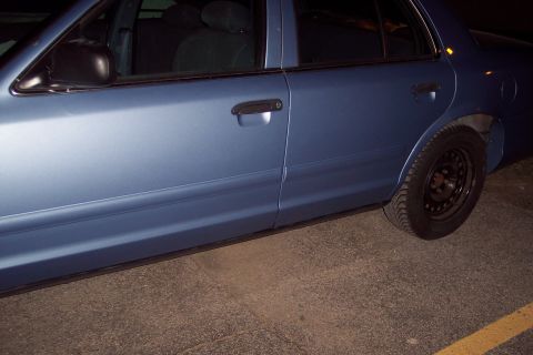 2001 Ford Crown Victoria - Blue 2001 Ford Crown Victoria sedan, side profile with black steel wheels.
