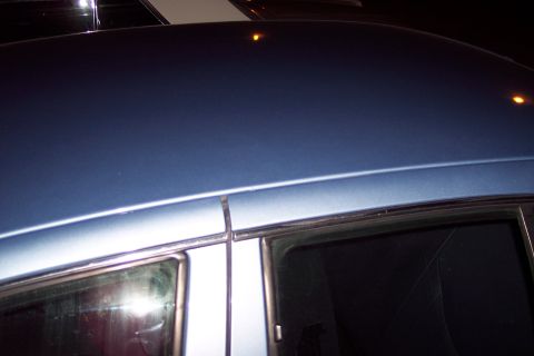 2001 Ford Crown Victoria - Close-up view of the roof and window trim on a blue sedan.