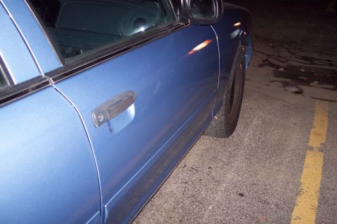 2001 Ford Crown Victoria - Side view of a blue 2001 Ford Crown Victoria showing the door handle and part of the rear wheel.