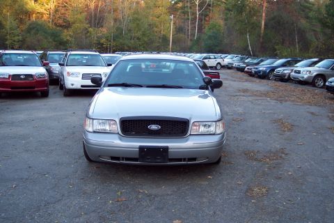 2001 Ford Crown Victoria - A silver Ford Crown Victoria is parked in a lot with many other vehicles. The grille indicates it is a 2004 model.