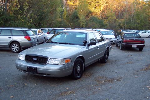 2001 Ford Crown Victoria - A silver 2001 Ford Crown Victoria is parked in an outdoor lot with several other vehicles visible.