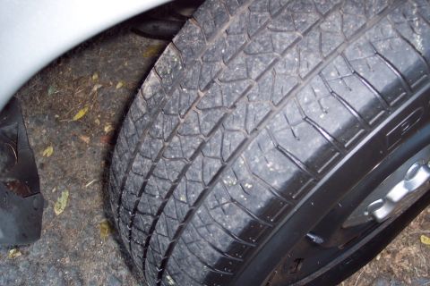 2001 Ford Crown Victoria - A close-up view of a tire and the surrounding wheel well area.