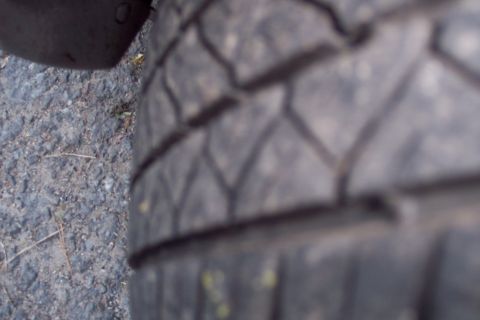 2001 Ford Crown Victoria - Close-up view of a tire tread on a paved surface.