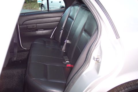 2001 Ford Crown Victoria - Interior view of a car's back seat and door panel, with a second vehicle seen outside.
