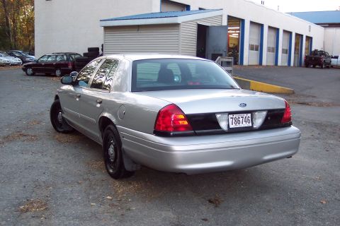 2001 Ford Crown Victoria - Rear view of a silver 2001 Ford Crown Victoria, showing its distinctive taillights and license plate.