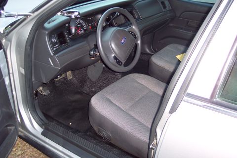 2001 Ford Crown Victoria - The interior of a 2001 Ford Crown Victoria, a gray cloth interior and a police-style spotlight mount.