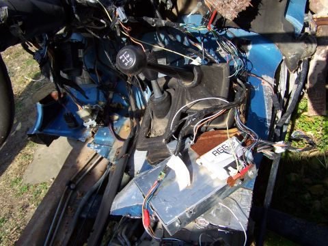 1995 Ford Bronco - Exposed wiring and electronic modules in a vehicle's interior, with a gear shift knob visible.