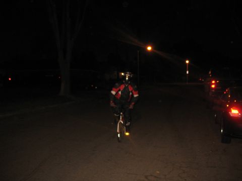 2007 Yamaha R1 - A person rides a bicycle at night, illuminated by streetlights and their own reflective gear.