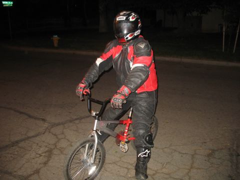 2007 Yamaha R1 - A person dressed in full motorcycle attire is seated on a bicycle at night.